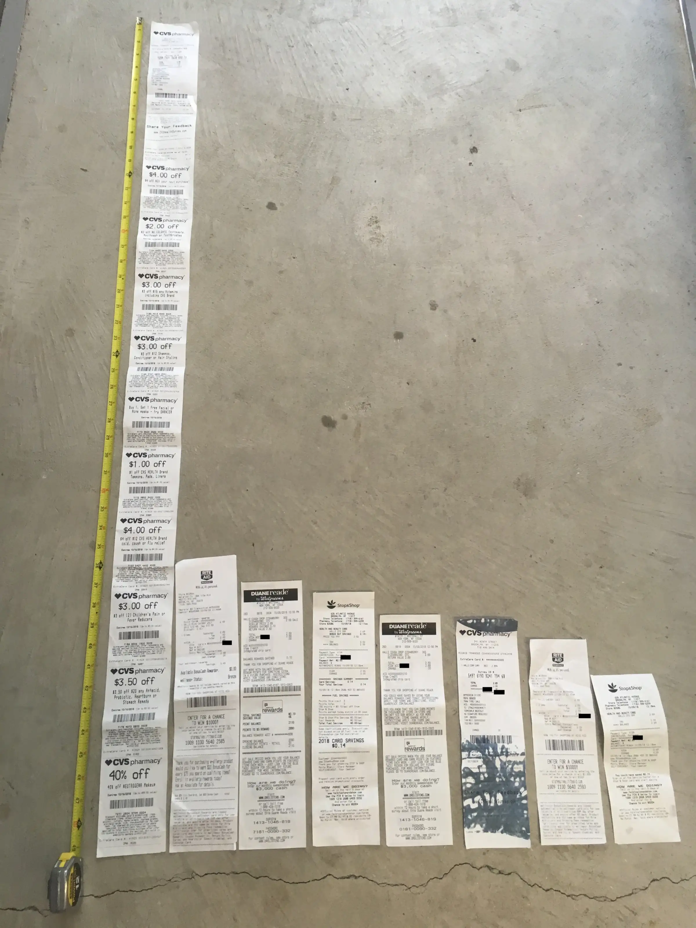 CVS receipt, left, is several feet long and shown next to a tape measure and other, normally-sized receipts.